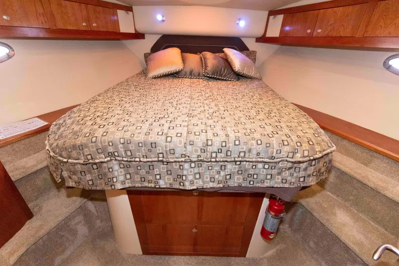 Slide: The Image of Luxurious 2005 Cruisers Yachts 405 Express Motoryacht bedroom with elegant bedding and wood cabinetry. - 20