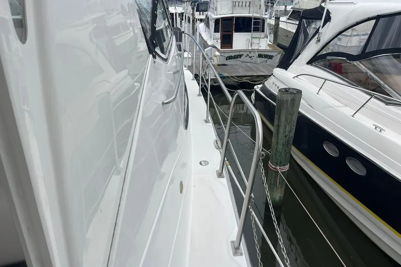 Slide: The Image of 2005 Cruisers Yachts 405 Express Motoryacht interior with seating and kitchenette, docked at marina. - 5