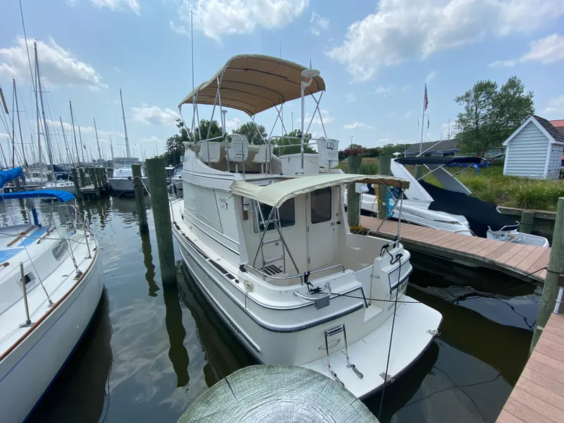 Slide: The Image of 1998 Camano Troll 31 boat docked at a marina under a partly cloudy sky. - 17
