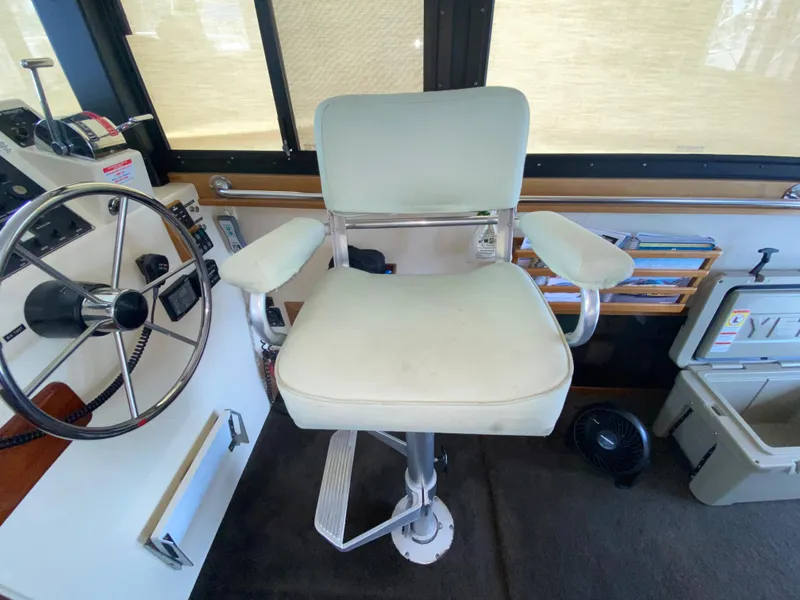 Slide: The Image of Captain's chair in 1998 Camano Troll 31 boat cockpit, featuring steering wheel and control panel. - 19