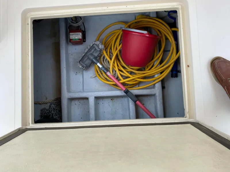 Slide: The Image of Storage compartment on a 1998 Camano Troll 31 with cleaning supplies and coiled hose. - 25