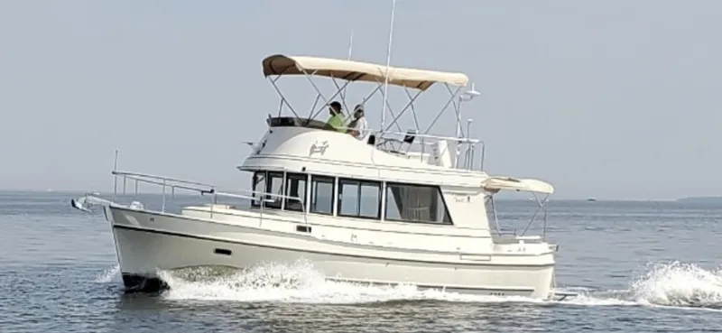 Slide: The Image of 1998 Camano Troll 31 cruising on calm waters with two people onboard. - 27