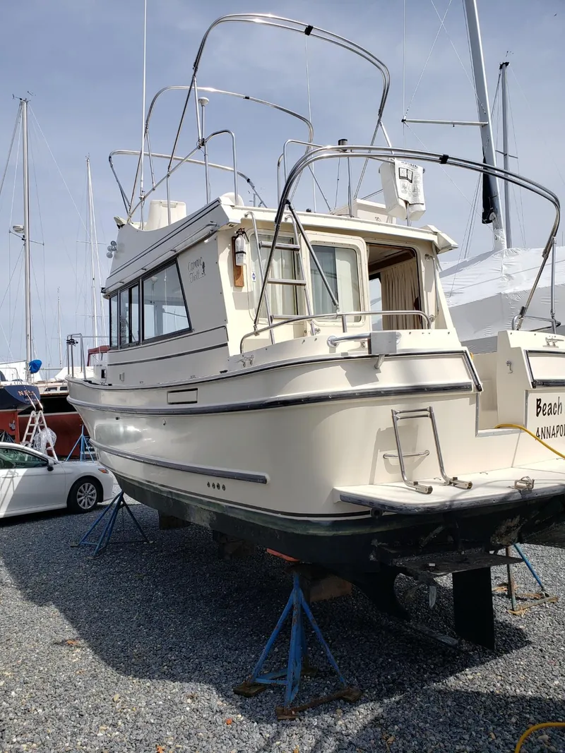 Slide: The Image of 1998 Camano Troll 31 boat on stands in a marina, side and rear view. - 29