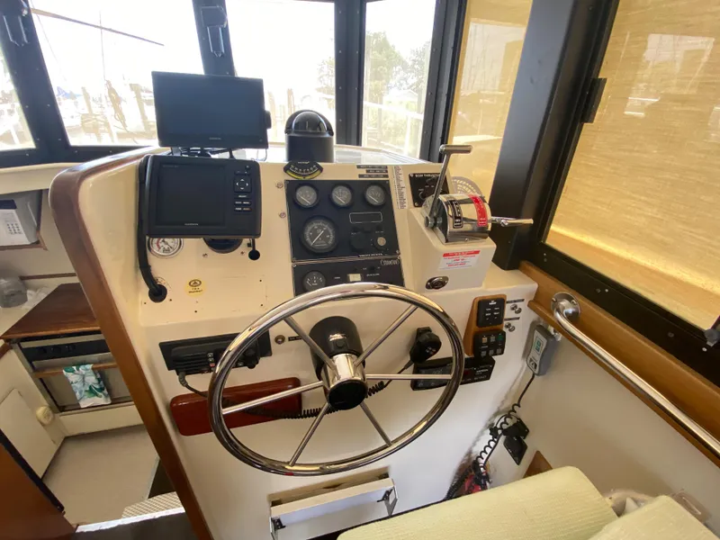 Slide: The Image of 1998 Camano Troll 31 boat helm with steering wheel and navigation instruments. - 3