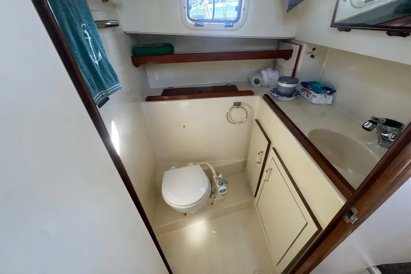 Slide: The Image of 1998 Camano Troll 31 boat bathroom with toilet, sink, and storage cabinets. - 49