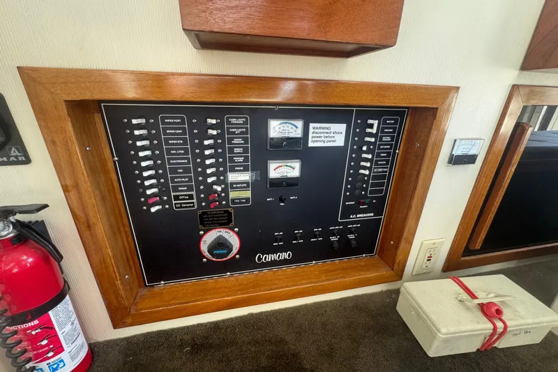 Slide: The Image of Electrical panel of a 1998 Camano Troll 31 boat, featuring switches and gauges. - 52