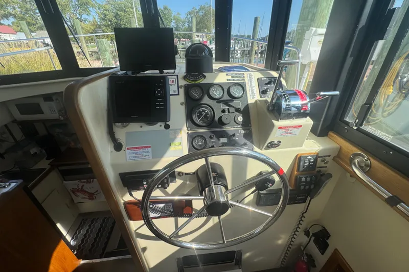 Slide: The Image of 1998 Camano Troll 31 helm with steering wheel, gauges, and navigation equipment. - 53