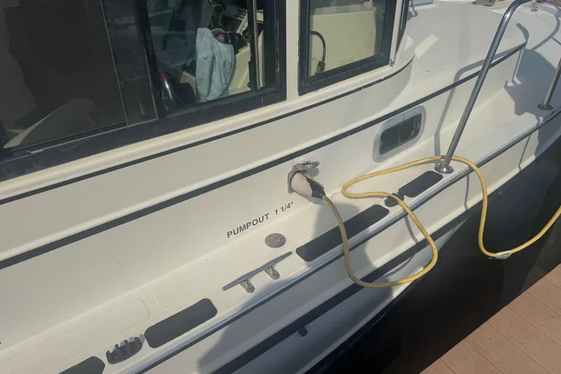 Slide: The Image of 1998 Camano Troll 31 boat with pumpout connection and yellow hose on deck. - 57