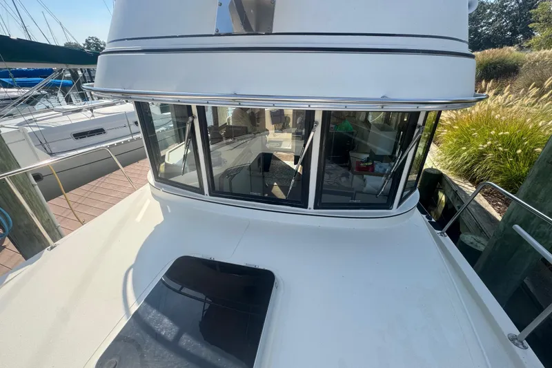 Slide: The Image of 1998 Camano Troll 31 boat docked, showcasing cabin windows and deck area. - 62