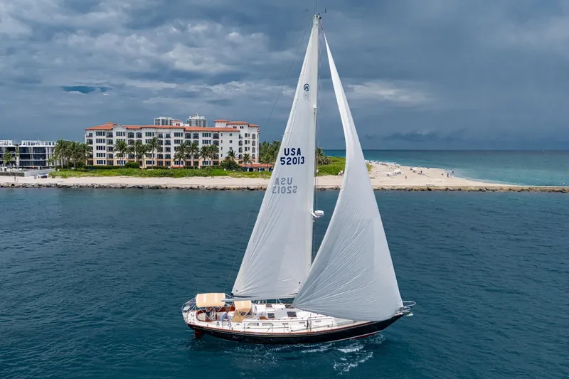 Slide: The Image of Hinckley Sou'wester Stoway Sloop sailing near a coastal resort, 2000 model. - 1