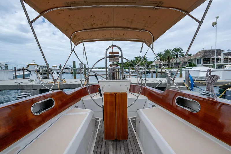 Slide: The Image of Hinckley Sou'wester Stoway Sloop 2000, elegant cockpit view at marina, wooden accents, canopy overhead. - 27