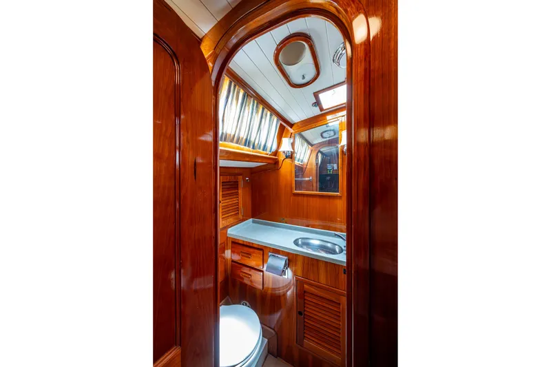 Slide: The Image of Luxurious wooden interior of 2000 Hinckley Sou'wester Stoway Sloop bathroom with sink and mirror. - 44