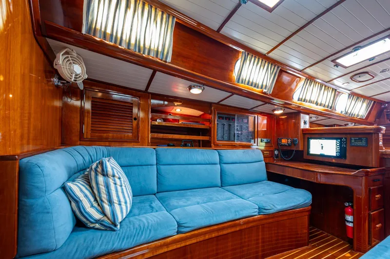 Slide: The Image of Interior of 2000 Hinckley Sou'wester Stoway Sloop with blue seating and wooden finishes. - 48