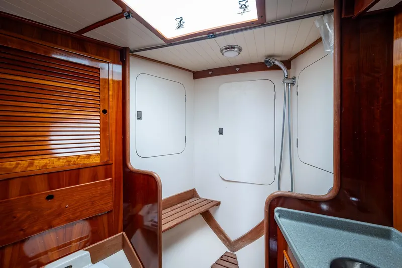 Slide: The Image of Hinckley Sou'wester Stoway Sloop 2000 interior with wooden cabinetry and shower area. - 59