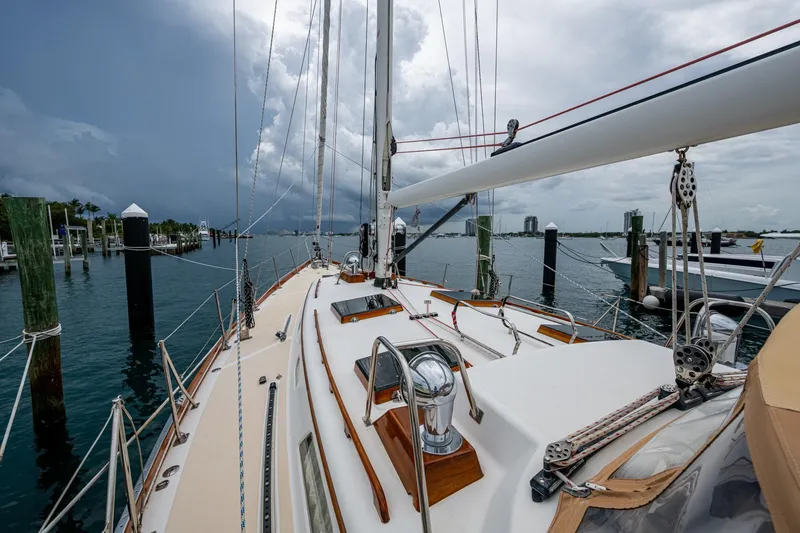 Slide: The Image of Hinckley Sou'wester Stoway Sloop 2000 docked, showcasing deck and rigging under cloudy skies. - 9