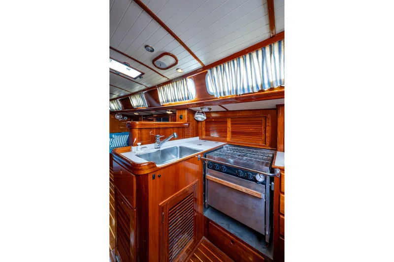 Slide: The Image of Hinckley Sou'wester Stoway Sloop 2000 interior kitchen with wood finish and modern appliances. - 38