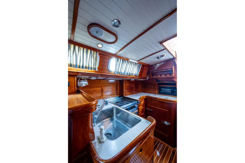 Slide: The Image of Hinckley Sou'wester Stoway Sloop 2000 interior kitchen with wood finish and modern appliances. - 41