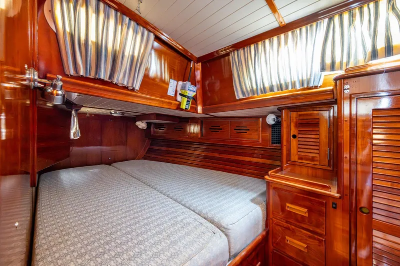 Slide: The Image of Luxurious wooden cabin interior of 2000 Hinckley Sou'wester Stoway Sloop with cozy bed and striped curtains. - 42