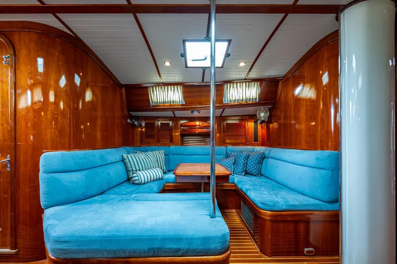Slide: The Image of Luxurious interior of 2000 Hinckley Sou'wester Stoway Sloop with blue seating and wooden finish. - 50