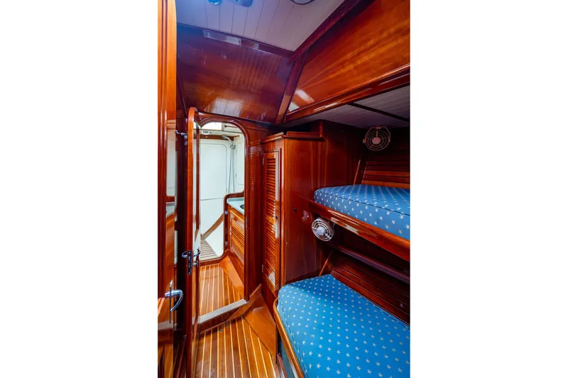 Slide: The Image of Hinckley Sou'wester Stoway Sloop 2000 interior with wooden finish and blue star-patterned bunks. - 53