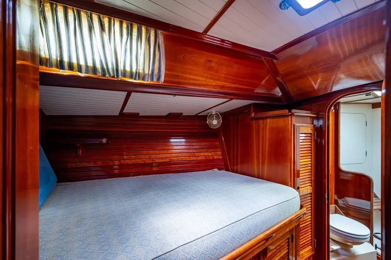 Slide: The Image of Hinckley Sou'wester Stoway Sloop 2000 interior cabin with wooden finish and cozy bed. - 55