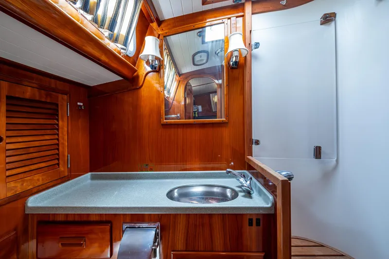 Slide: The Image of Hinckley Sou'wester Stoway Sloop 2000 bathroom with wooden cabinetry and modern fixtures. - 58