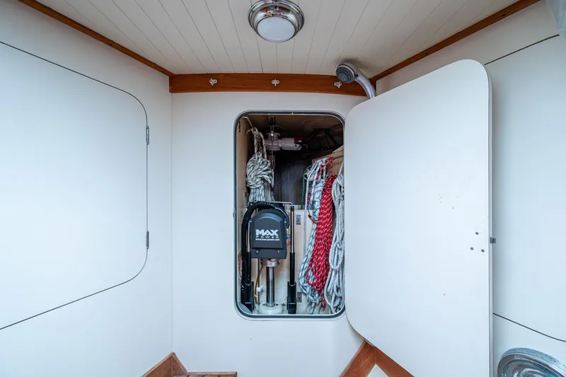 Slide: The Image of Interior of 2000 Hinckley Sou'wester Stoway Sloop with storage compartment and ropes. - 61