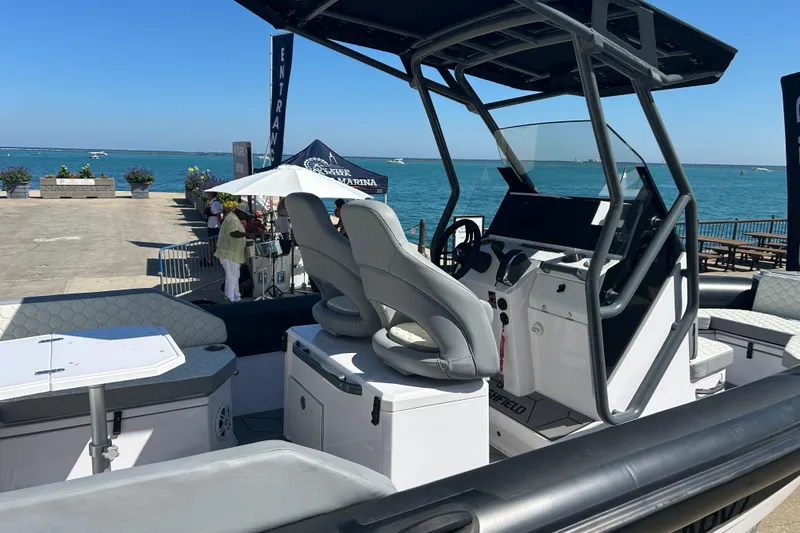 Slide: The Image of 2026 Highfield ADV 7 boat dashboard with Mercury controls at a boat show. - 11