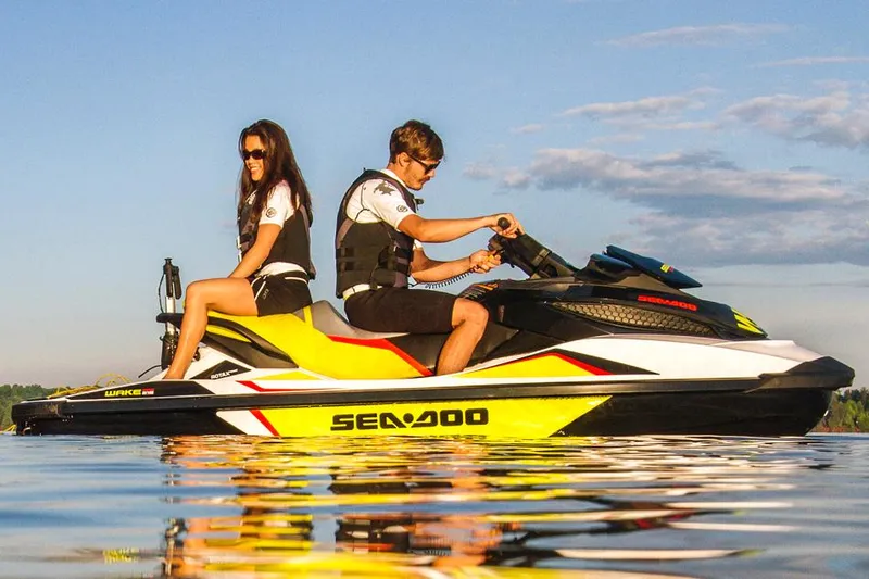Slide: The Image of 2014 Sea-Doo Wake Pro 215 jet ski on water with two riders enjoying a sunny day. - 23
