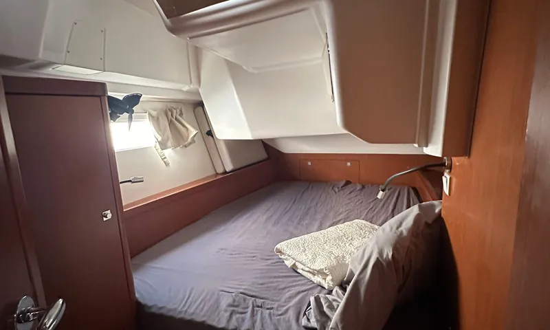 Slide: The Image of Cozy cabin interior of 2014 Beneteau Oceanis 41 sailboat with bed and window. - 14