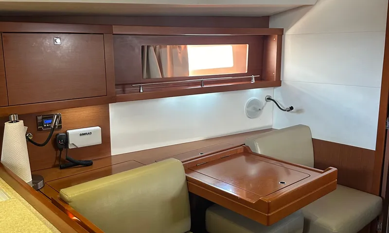 Slide: The Image of Interior of 2014 Beneteau Oceanis 41 sailboat with wooden table and seating area. - 8