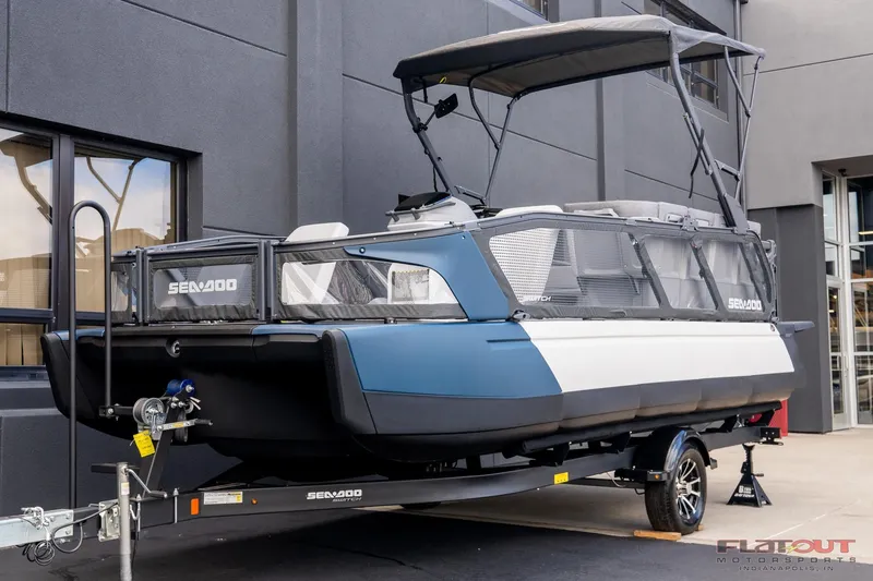 Slide: The Image of 2024 Sea-Doo Switch SPORT 21 230HP pontoon boat on trailer, outdoor display. - 0