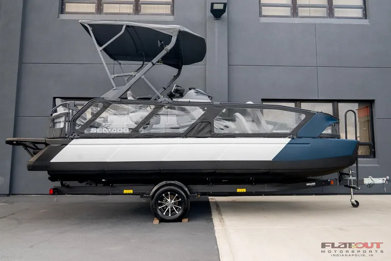 Slide: The Image of 2024 Sea-Doo Switch SPORT 21 230HP pontoon boat on trailer, side view. - 2
