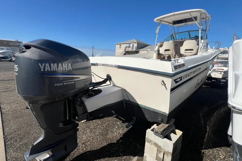 Slide: The Image of 1983 Grady-White boat with Yamaha outboard motor, parked on gravel. - 3