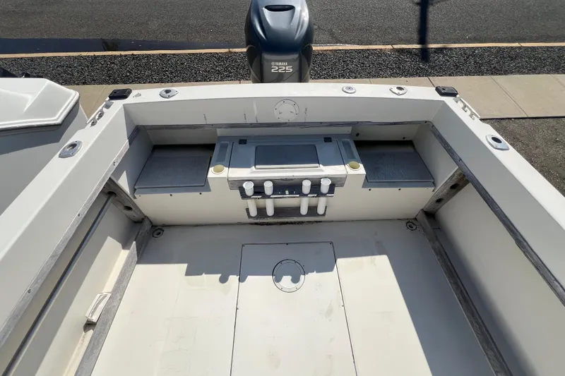 Slide: The Image of 1983 Grady-White boat interior with Yamaha 225 engine, featuring storage compartments and rod holders. - 5