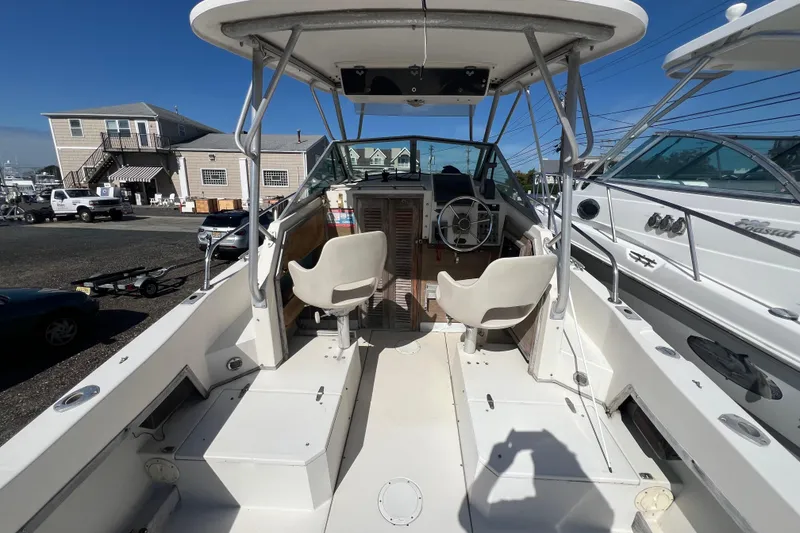 Slide: The Image of 1983 Grady-White boat interior with helm, seats, and marina background. - 6