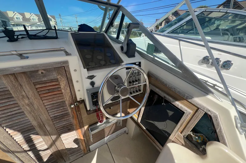 Slide: The Image of 1983 Grady-White boat cockpit with steering wheel and control panel, showcasing vintage design. - 7