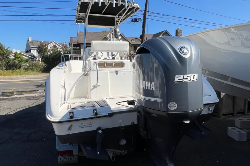 Slide: The Image of 2000 Cobia 224 Center Console boat with Yamaha 250 engine, parked outdoors. - 2