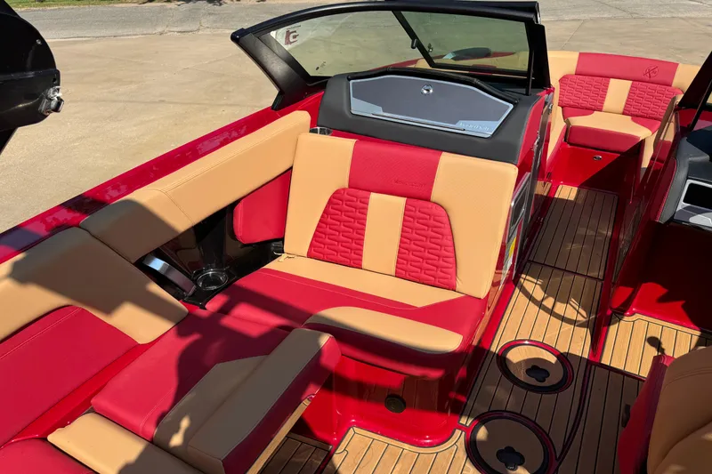 Slide: The Image of 2022 MasterCraft X24 boat interior with red and tan seating, wood flooring. - 10