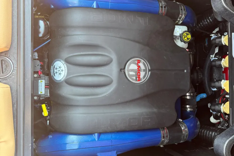 Slide: The Image of 2022 MasterCraft X24 Ilmor engine with blue hoses and black cover. - 19