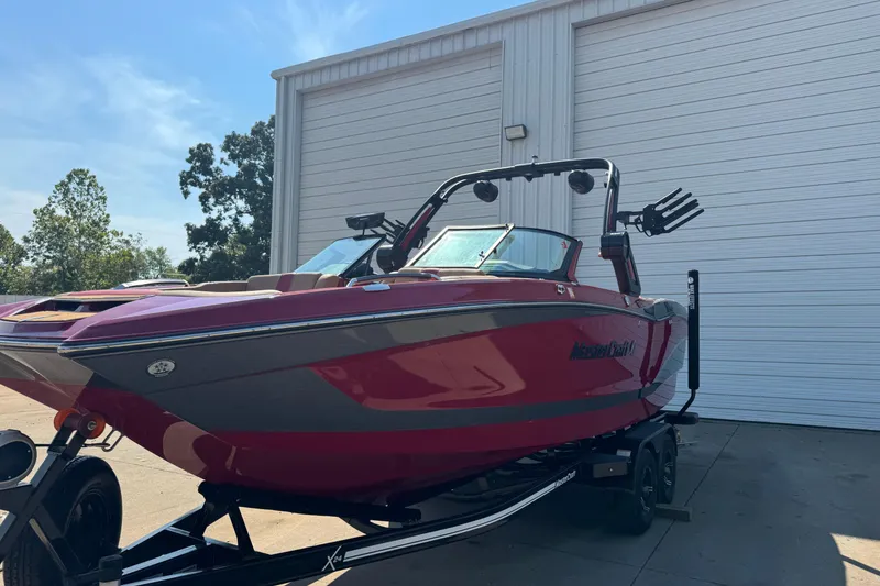 Slide: The Image of 2022 MasterCraft X24 boat in vibrant red, parked outside a garage. - 3