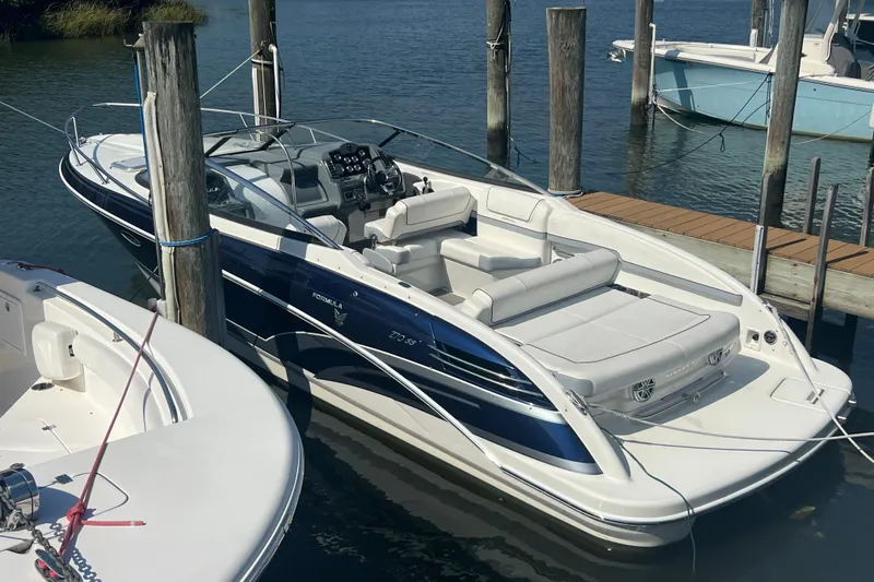 Slide: The Image of 2018 Formula 270 Sun Sport boat docked, featuring sleek design and spacious seating. - 2
