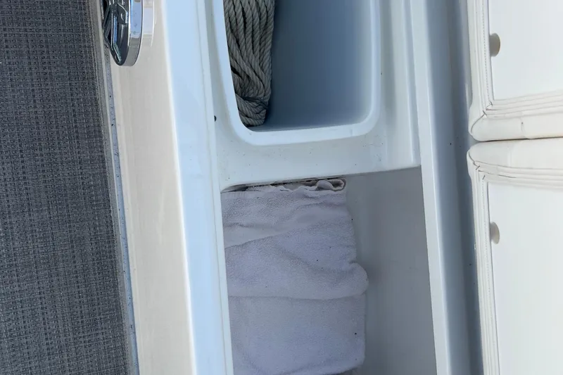 Slide: The Image of Storage compartment on a 2018 Formula 270 Sun Sport boat with rope and towel. - 24