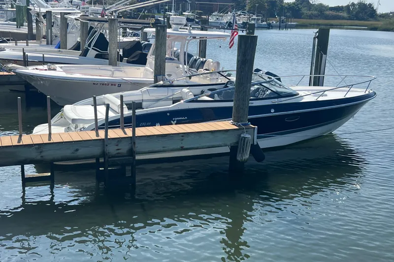 Slide: The Image of 2018 Formula 270 Sun Sport boat docked in a marina, calm water setting. - 3