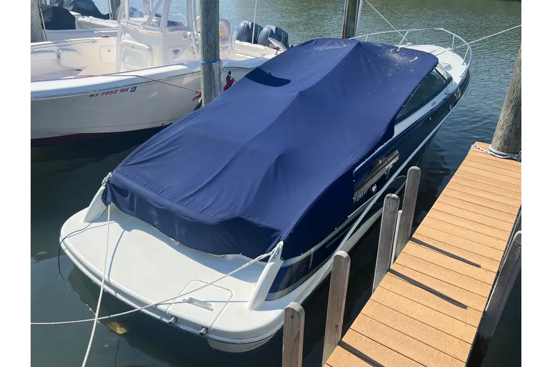 Slide: The Image of 2018 Formula 270 Sun Sport boat docked with blue cover, side view. - 5