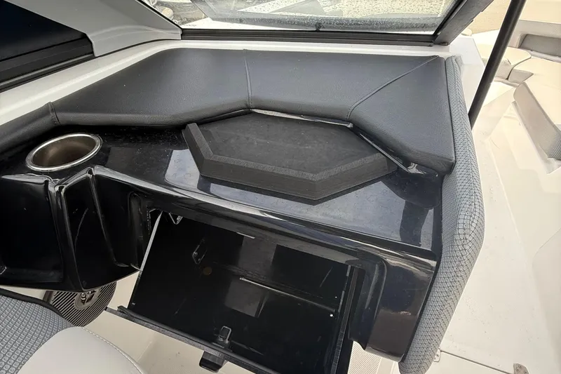 Slide: The Image of 2025 Scarab 235SE boat interior with storage compartment and cup holder. - 14