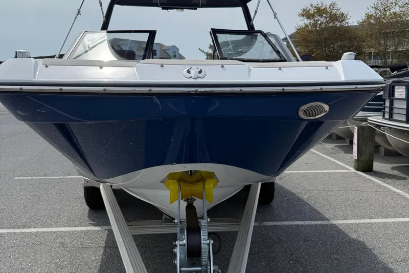 Slide: The Image of 2025 Scarab 235SE boat on trailer, front view, parked outdoors. - 3