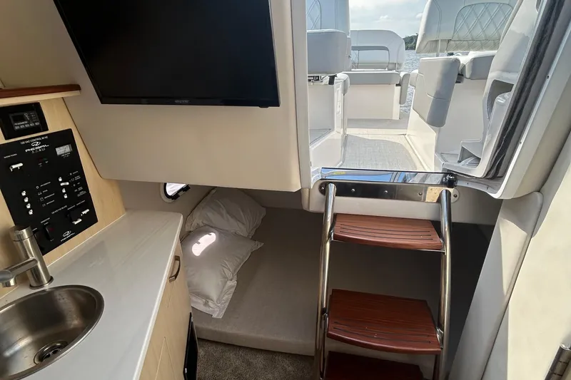 Slide: The Image of 2024 Regal 26 XO cabin interior with kitchenette, TV, and access to deck. - 24