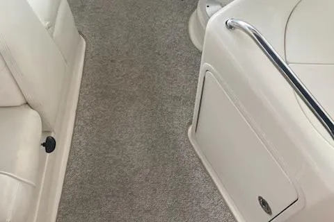 Slide: The Image of 2004 Sea Ray 280 Sundancer interior with white seating and carpeted flooring. - 12