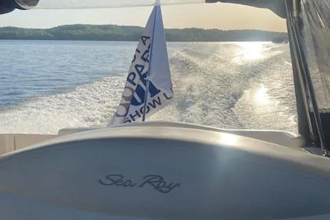 Slide: The Image of 2004 Sea Ray 280 Sundancer cruising on a sunny lake with a flag waving. - 2
